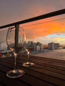 达尔文Darwin City Suites with Harbour View的两杯酒杯坐在阳台上欣赏日落美景