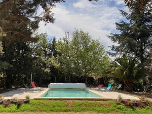 贝济耶Chambres d'hôtes dans propriété rurale的庭院内的游泳池,带椅子和树木