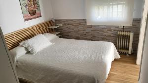 埃斯帕尔蒂纳斯Apartamento EL REAL - Espartinas - SEVILLA的一间卧室设有一张床和砖墙