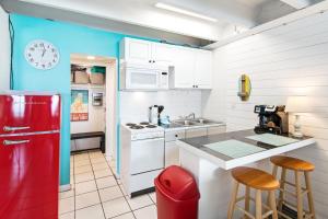 巴拿马城海滩Fontainebleau Terrace的厨房配有红色冰箱和带凳子的台面