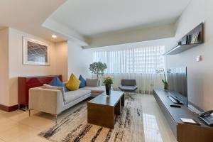 迪拜朱美拉世贸中心住宿、套房及酒店公寓的客厅配有沙发和桌子