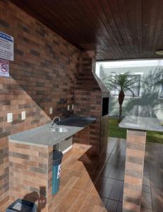 蓬塔格罗萨Apartamento novo wi-fi + TV的厨房设有水槽和砖墙