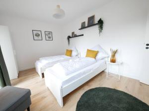 奥斯纳布吕克69 m², zentral, Balkon, stilvoll的白色的客厅配有白色的沙发和黄色的枕头。