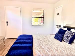佩森Upgraded, Stylish & Comfy 1 Bedroom/1 Bath Studio的一间卧室配有一张带蓝色枕头的床和一扇窗户。