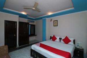 RāmpuraOYO 13161 Apni Havali Hotel & Restaurant的一间卧室配有红色枕头的床