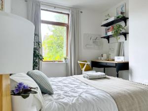 曼彻斯特Beautiful Private Room in Levenshulme的一间卧室配有一张带书桌的床和窗户。