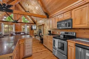 尤里卡斯普林斯Main Lodge at Lake Forest Cabins的厨房配有木制橱柜和炉灶烤箱。