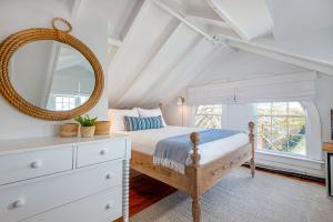 楠塔基特Nantucket Periwinkle的一间卧室配有一张带镜子和梳妆台的床