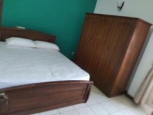 科伦坡Rudra Residence Apartment的一间卧室配有木床和木制梳妆台