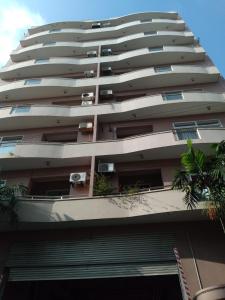 科伦坡Rudra Residence Apartment的一座高大的公寓楼,前面有棕榈树