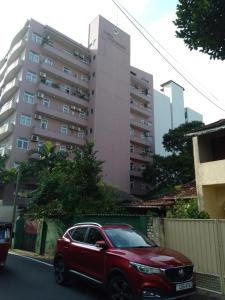 科伦坡Rudra Residence Apartment的停在高楼前的红色汽车