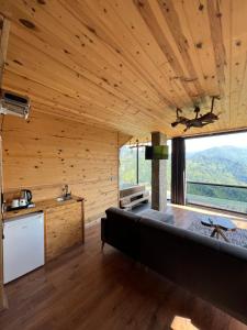 贾马里海姆森Nirvana dağ evleri的一间配有沙发和大窗户的客房