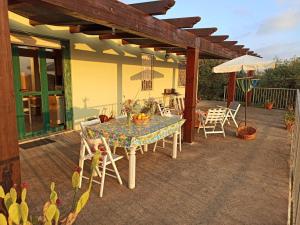 阿尔盖罗Villa Tramonto的庭院配有桌椅和遮阳伞。