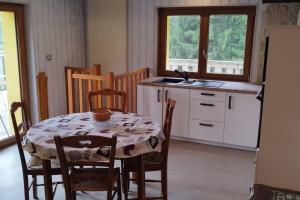 旺特龙Maison de montagne vue magnifique的带桌椅的厨房和带水槽的厨房