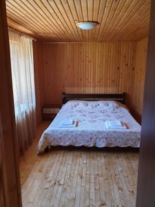 沃洛韦齐Зачаровані Карпати, Воловець的木制客房内的一间卧室,配有一张床