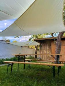 布鲁塞尔Superbe appartement avec jardin, sauna et jacuzzi的树旁白色帐篷下的野餐桌