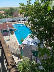 Byal IzvorGuest House KOLESHEVI的享有带桌子和长凳的游泳池的景色