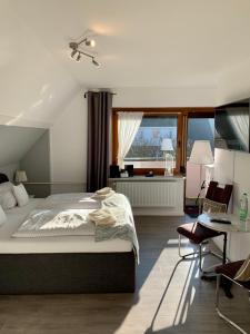 比苏姆Ferienwohnung und Appartementvermietung Haus-Kaiser的一间卧室配有一张床、一张书桌和一个窗户。