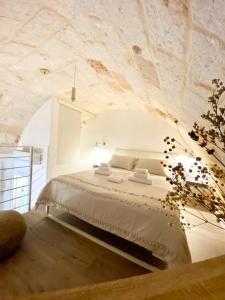 滨海波利尼亚诺Stella Marina Luxury的卧室配有一张石墙内的大床