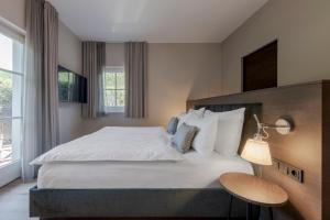 博尔扎诺玛格达勒内霍夫酒店的卧室设有一张白色大床和一扇窗户。