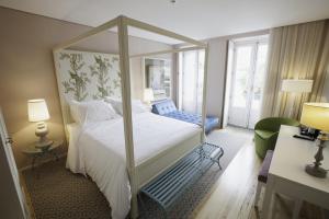 波尔图波尔图画廊住宿加早餐旅馆的一间卧室配有一张带天蓬的大型白色床