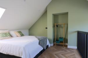 WeerseloErve Mulder vakantiehuis met eigen jacuzzi en eigen sauna的卧室配有白色的床和楼梯。