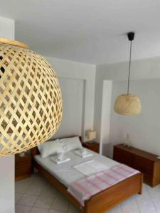 斯卡拉Cozy studio in Skala, Agistri的一间卧室配有床和柳条灯
