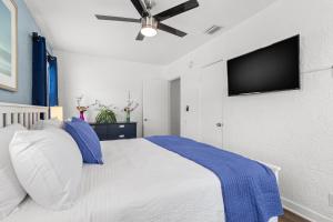 圣徒皮特海滩Park Shore Suites at Madeira Beach的卧室配有白色的床和平面电视。