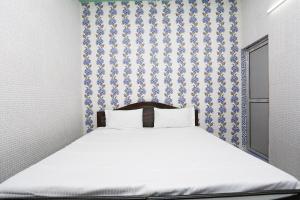 鲁尔基SPOT ON Hotel Doon Sabri的一间卧室配有一张蓝色和白色壁纸的床