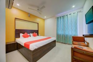 海得拉巴OYO Hotel Meredian Orchid Near Birla Mandir的一间卧室配有一张大床和电视