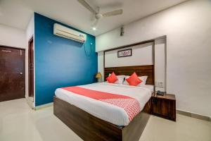 海得拉巴OYO Hotel Meredian Orchid Near Birla Mandir的一间卧室配有一张带红色枕头的大床
