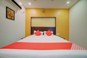 海得拉巴OYO Hotel Meredian Orchid Near Birla Mandir的一间卧室配有一张带红色枕头的大床
