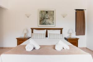 NerotriviáKouvelia Country Home Luxury Villa Rental的一间卧室配有一张带两盏灯的大型白色床。