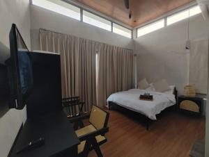 波德申Ocean Nadi 4 Bedrooms Beachfront Villa PD的一间卧室配有一张床,并在一间客房内配有电视。