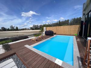 波德申Ocean Nadi 4 Bedrooms Beachfront Villa PD的一个带木制甲板和游泳池的游泳池