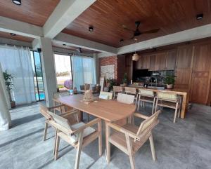 波德申Ocean Nadi 4 Bedrooms Beachfront Villa PD的一间带木桌和椅子的用餐室