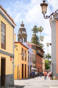 拉拉古纳Marhaba La Laguna, alojamiento en centro histórico de San Cristóbal de La Laguna的一条城市街道,后面有钟楼