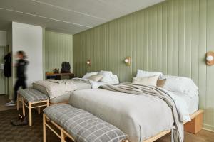 普莱西德湖Bluebird Lake Placid的带绿色墙壁的客房内的三张床