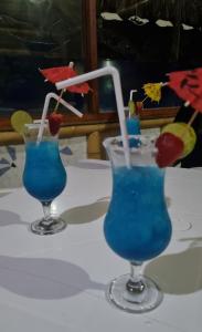 洛斯拉甘斯Bora Bora Bungalows的桌上的两份蓝调鸡尾酒和草