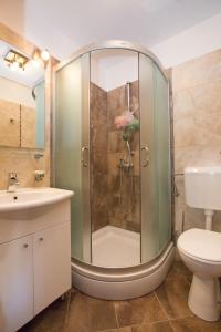 斯潘卡卢卡Apartments Orica II的带淋浴、卫生间和盥洗盆的浴室