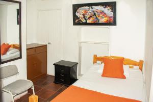 波哥大Hotel BogoSuba 127的一间卧室配有一张床、镜子和椅子