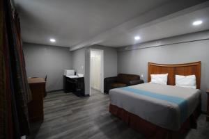 圣贝纳迪诺Starlite Motel的配有一张床和一把椅子的酒店客房