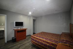 圣贝纳迪诺Starlite Motel的一间卧室配有一张床,梳妆台上配有电视