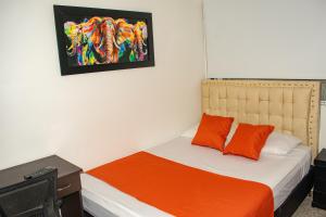 波哥大Hotel BogoSuba 127的一间卧室配有一张带橙色毯子的床