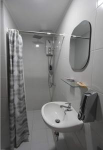 宿务Our oasis in Cebu City awaits you!的白色的浴室设有水槽和镜子