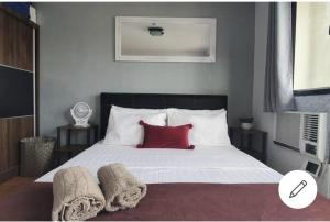 宿务Our oasis in Cebu City awaits you!的一间卧室配有一张带红色枕头的大床