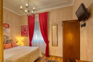 热那亚梦德娜洛坎达别墅酒店的一间卧室配有床和红色窗帘的窗户
