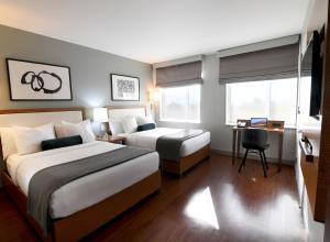 纽约华盛顿高地边缘酒店的酒店客房配有两张床和一张书桌
