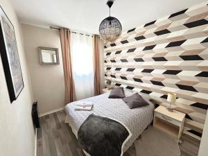 鲁昂SPACIEUX DUPLEX PRES DES QUAIS DE SEINE LINGE MAISON TOUT FOURNI PARKING GRATUIT bienvenue的一间卧室设有一张床和几何墙