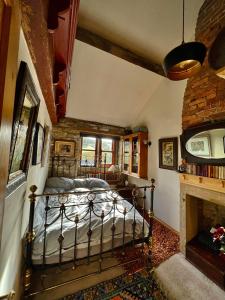 霍姆弗斯The Writers Cottage - Intriguing & Romantic的带壁炉的客房内的一间卧室配有一张床